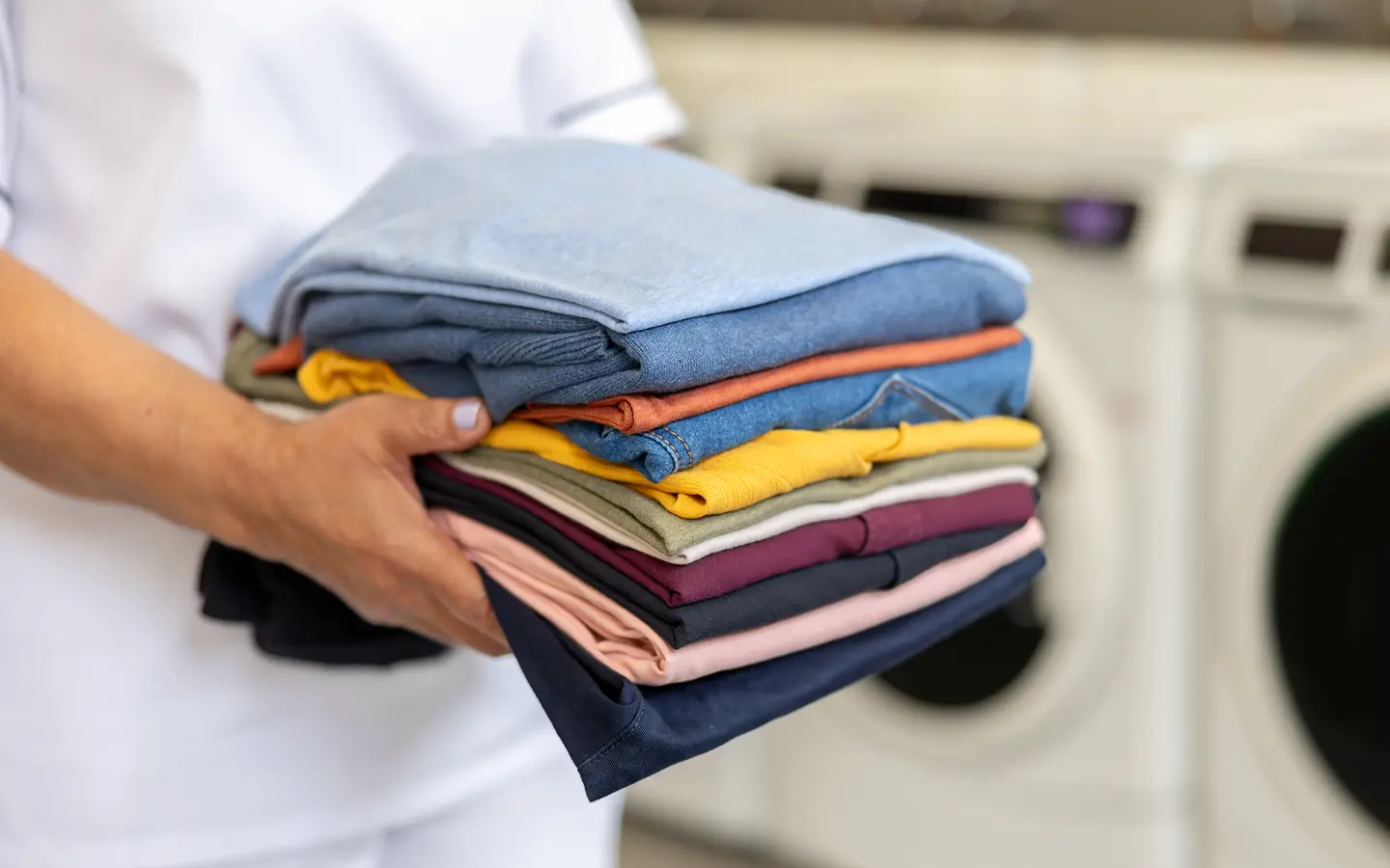 Person holding folded clothes